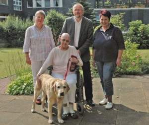 Betriebspraktikum 2010 im Hospiz St. Hildegard (v.l.n.r. Barbara Glunz, Koordinatorin für die Hospizarbeit, Axel Schäfer, Sabine Wüst, Pflegedienstleitung und vorne: Gast Heidemarie Olbrich mit Charly) Bildquelle: Andrea Schröder